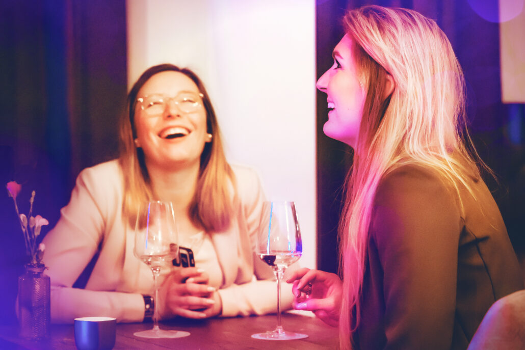 Zwei glückliche Gäste lachen fröhlich im B.FOR Kitchen & Bar