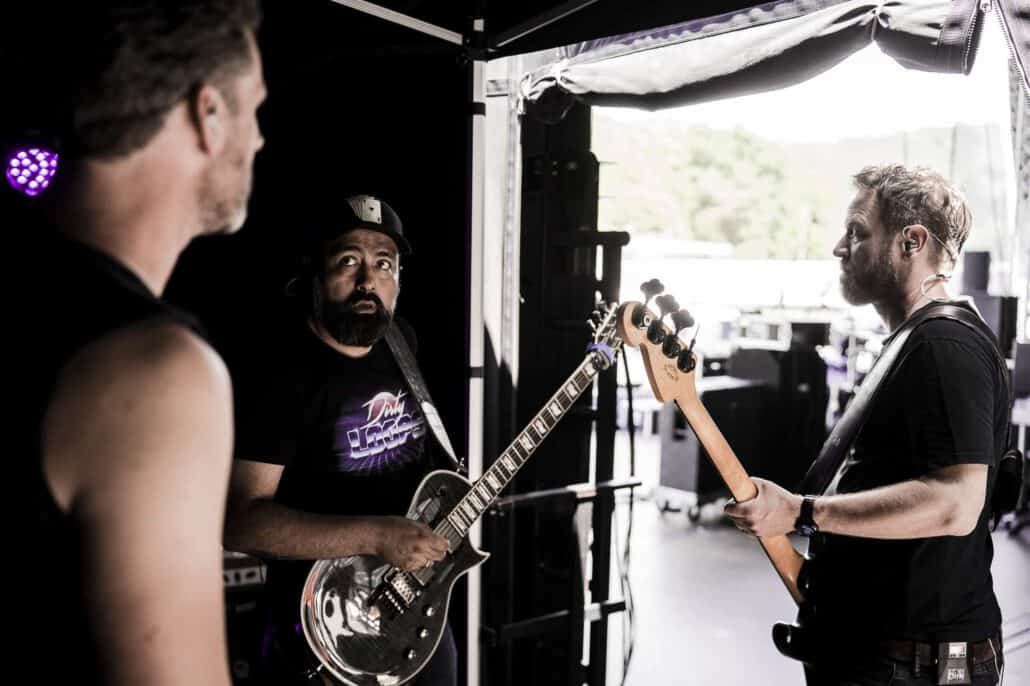 Bandsmitglieder besprechen Gitarrenpart backstage.