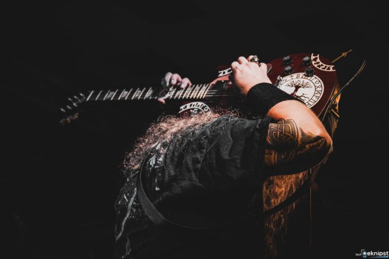 Gitarrist spielt auf einer dekorierten E-Gitarre.
