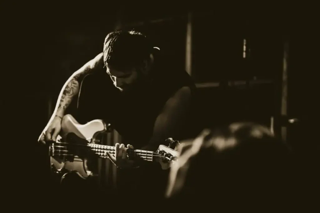 Gitarrist spielt intensiv auf der Bühne in Schwarz-Weiß.