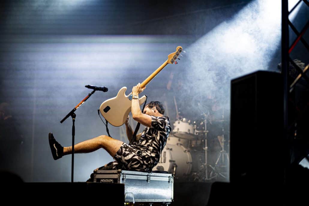 Gitarrist springt während eines Konzertes auf der Bühne.