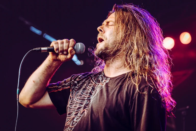 Rockmusiker singt leidenschaftlich auf Bühne bei Konzert.
