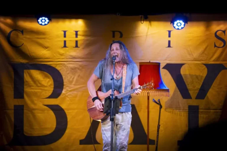 Musiker singt leidenschaftlich mit Gitarre auf Bühne.