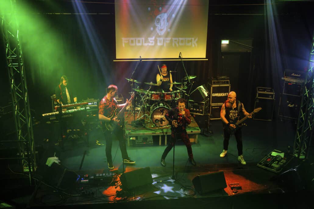 Rockband auf Bühne mit grüner Beleuchtung