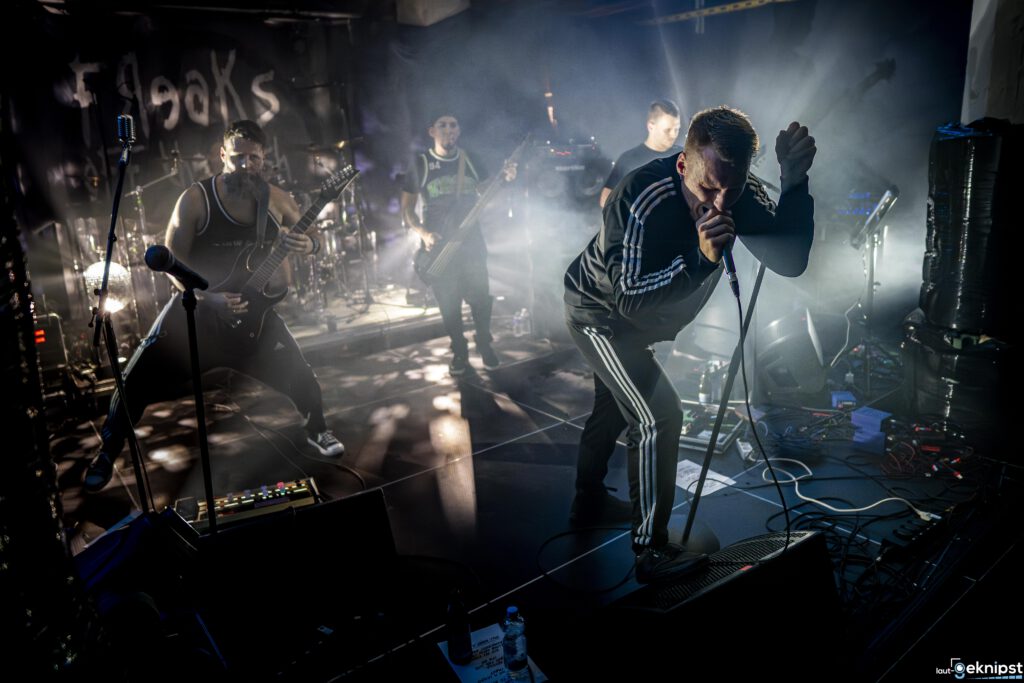 Rockband performt energisch auf einer beleuchteten Bühne.