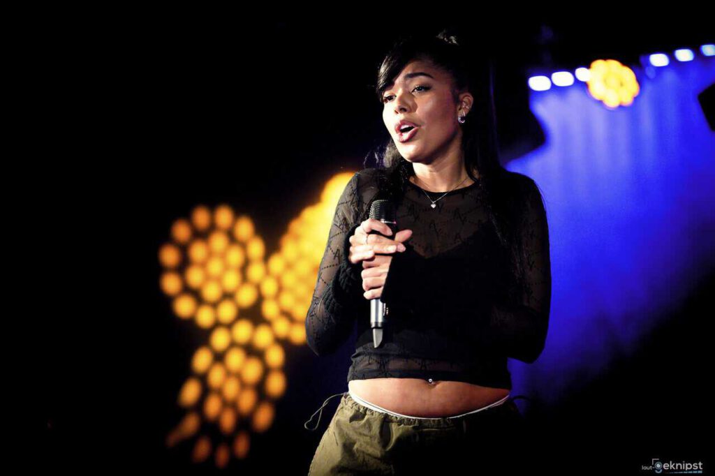 Sängerin performt live auf Bühne mit Mikrofon.