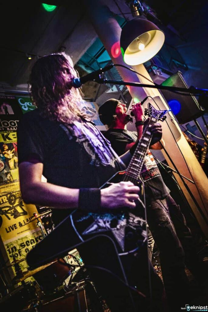 Rockmusiker spielen live auf einer beleuchteten Bühne.