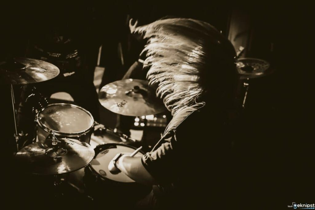 Schlagzeuger in Aktion bei Dunkelheit.