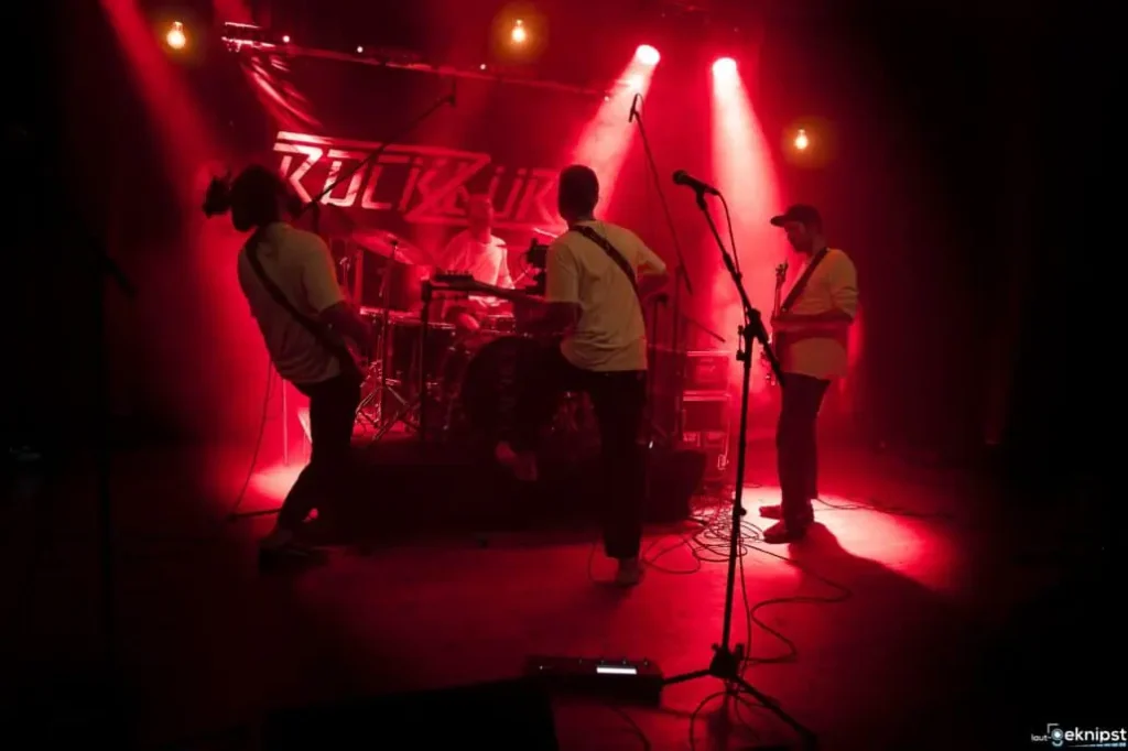 Band spielt live auf einer beleuchteten Bühne.