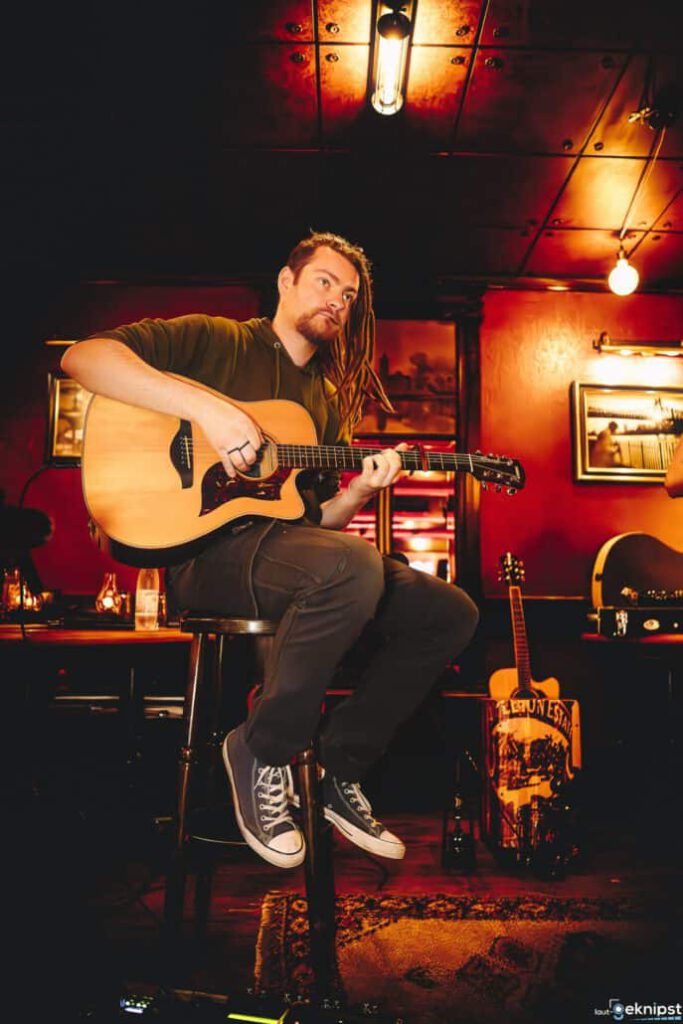 Gitarrist spielt Musik in einem beleuchteten Bar-Ambiente.