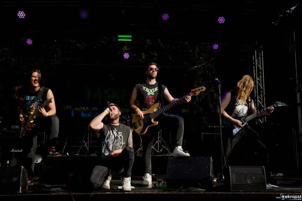 Rockband performt leidenschaftlich auf Freiluftbühne.