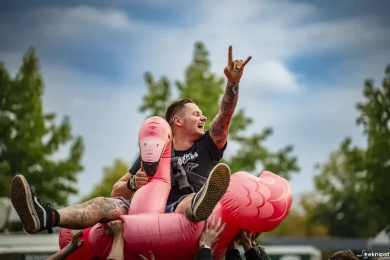 Mann feiert auf aufblasbarem Flamingo.