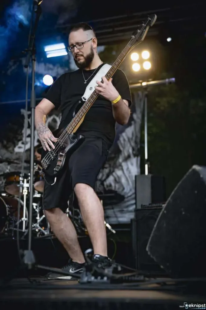 Bassist spielt auf Bühne bei einem Konzert.