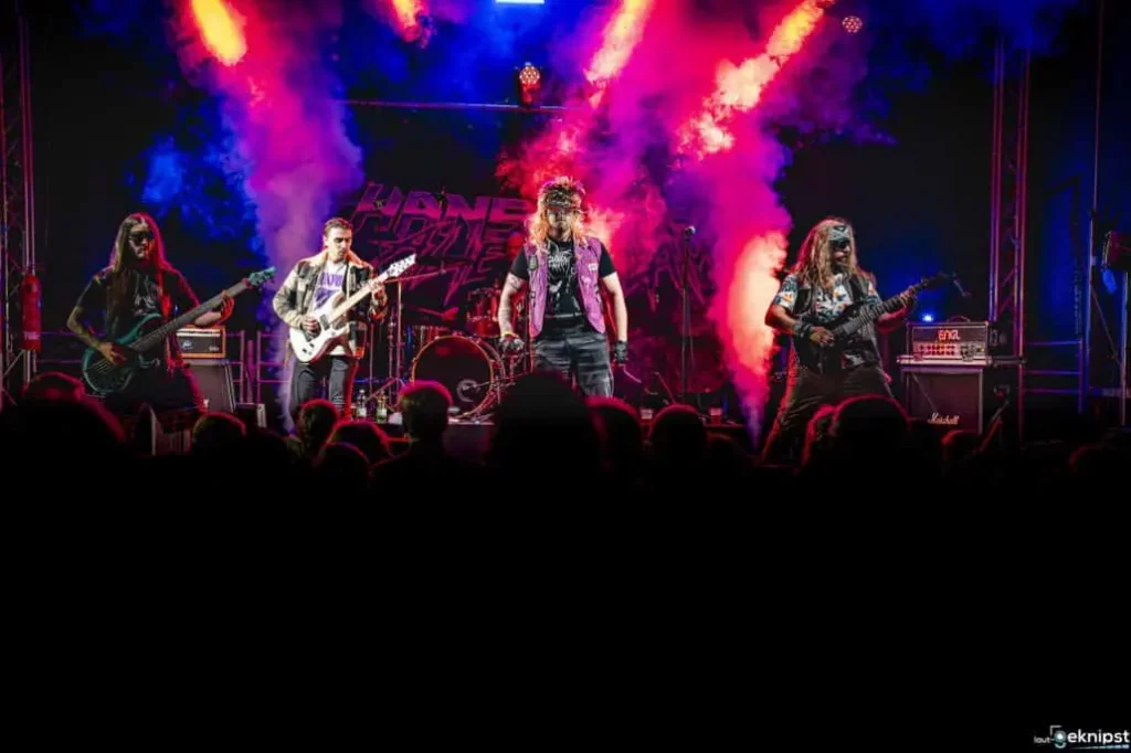 Rockband spielt live auf der Bühne mit farbigem Licht.