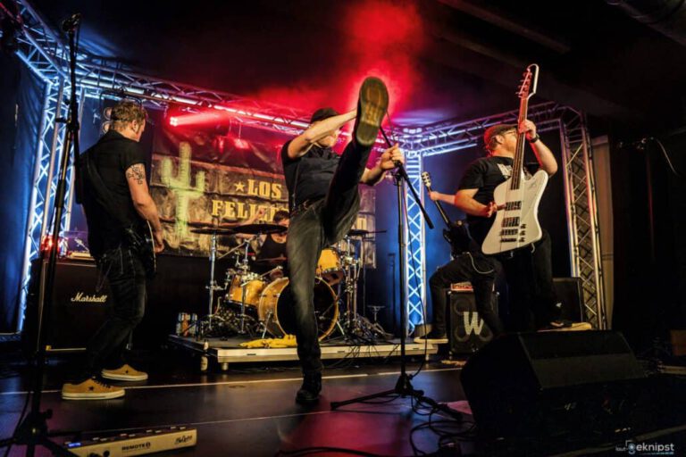 Rockband spielt energiegeladen auf einer Bühne.