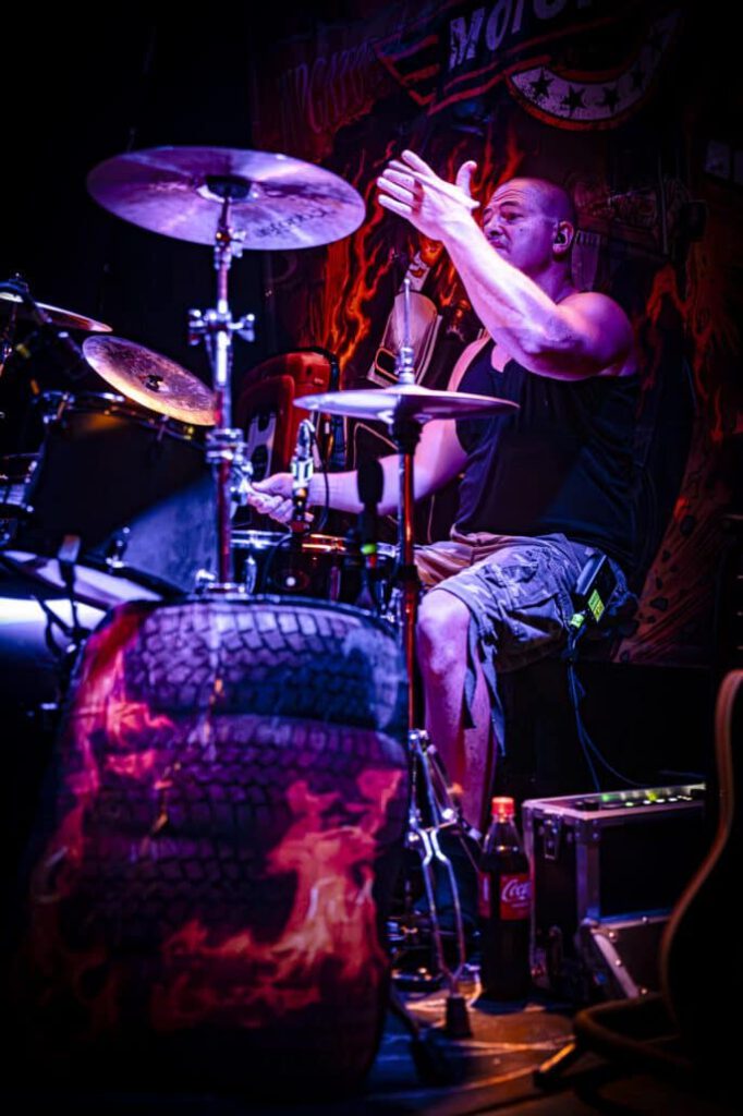 Schlagzeuger spielt energetisch bei einem Live-Konzert.