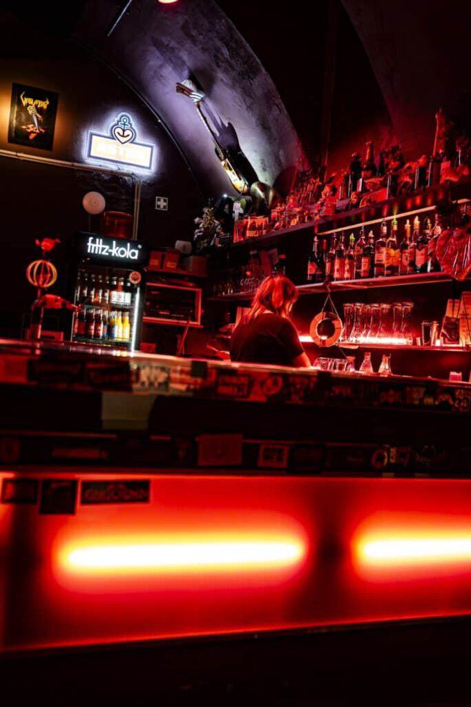 Stimmungsvolle Bar mit roter Beleuchtung und Barkeeperin.