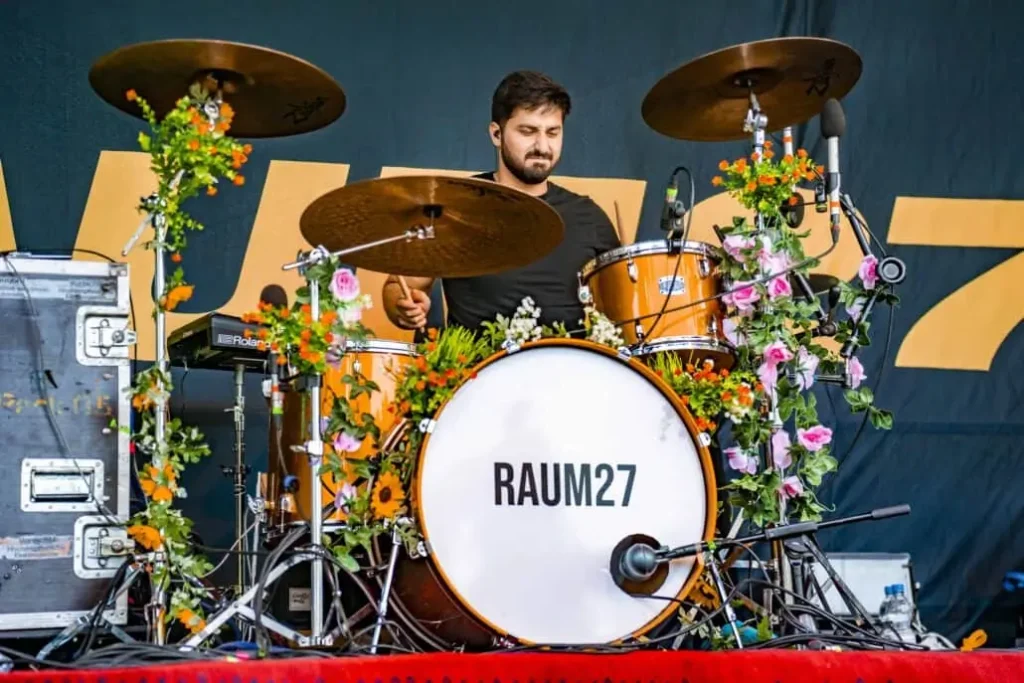 Schlagzeuger mit blumengeschmücktem Drumset "RAUM27
