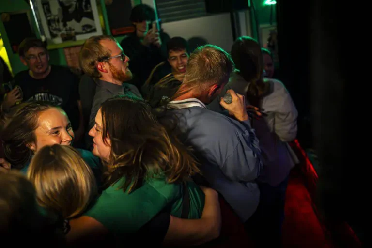 Leute tanzen und singen bei Nachtclubparty.