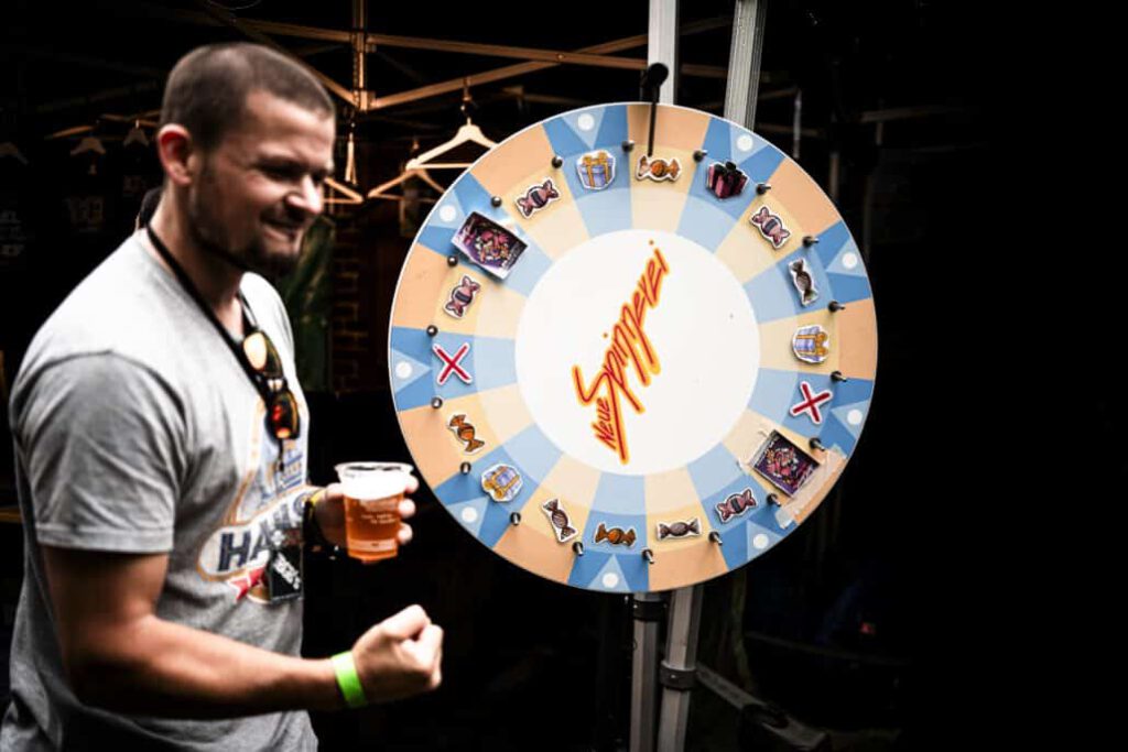 Mann spielt Glücksrad auf Bierfestival.