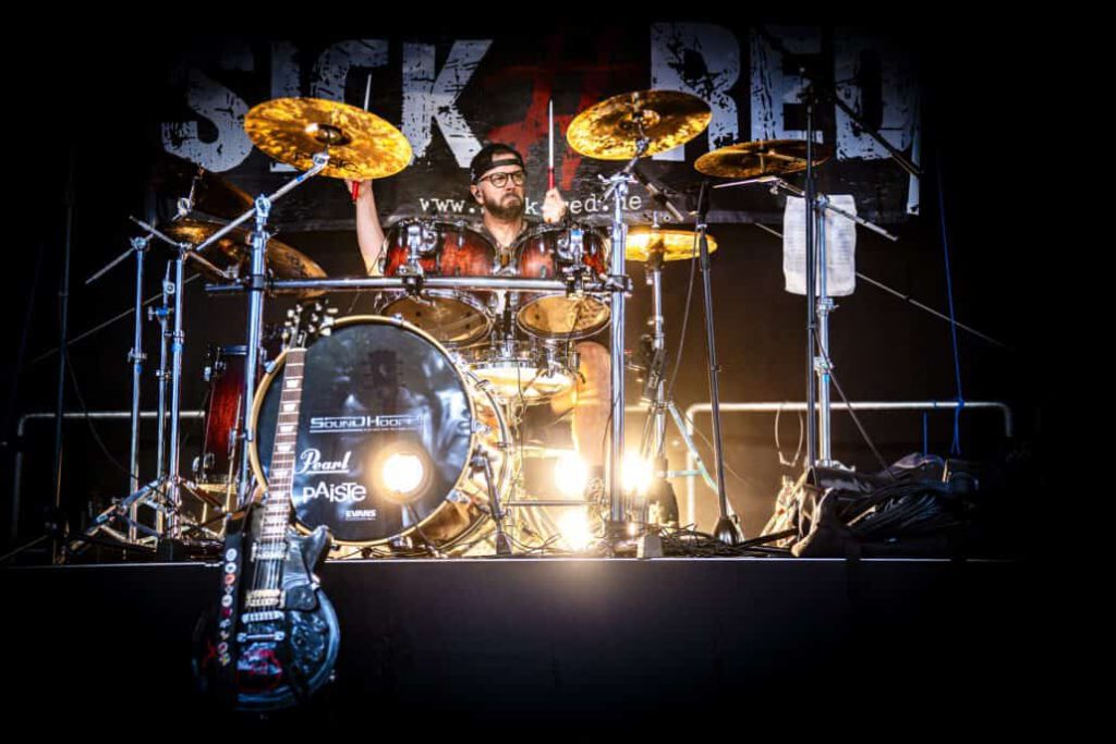 Schlagzeuger live auf der Bühne bei Nacht.