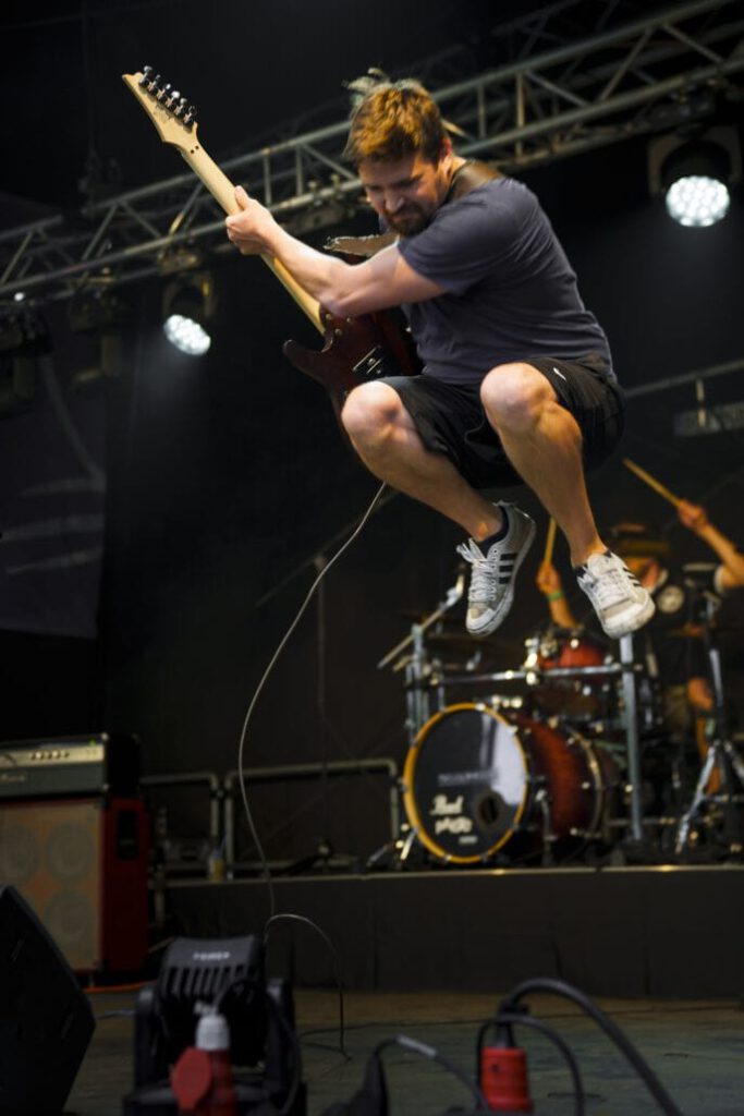 Gitarrist springt bei Live-Konzert.