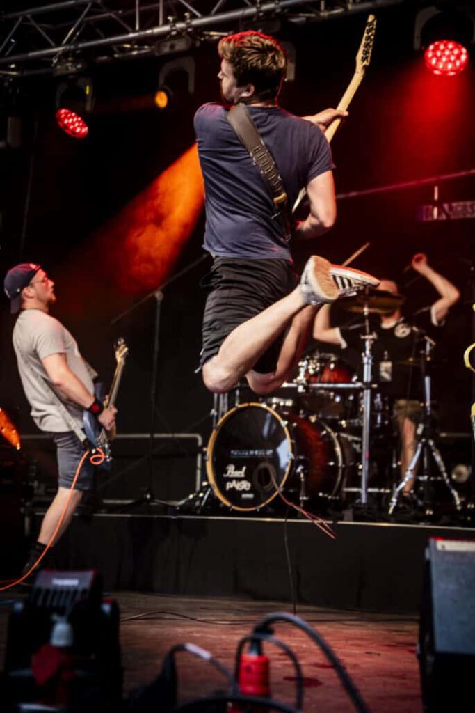 Gitarrist springt energisch bei einem Live-Konzert.