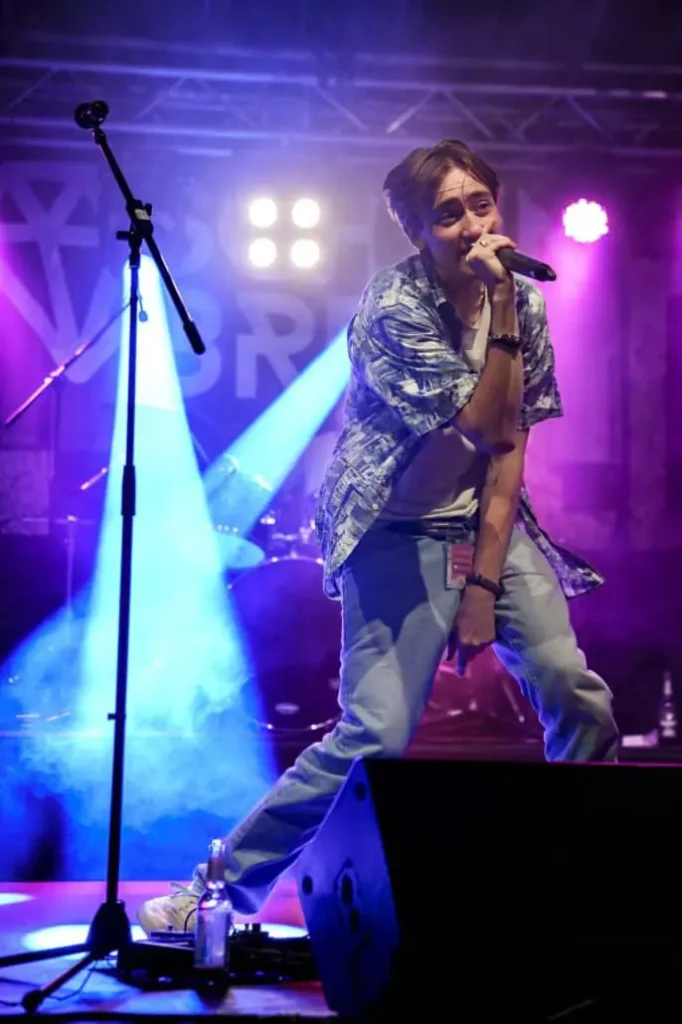 Sänger performt leidenschaftlich auf Bühne mit Mikrofon.