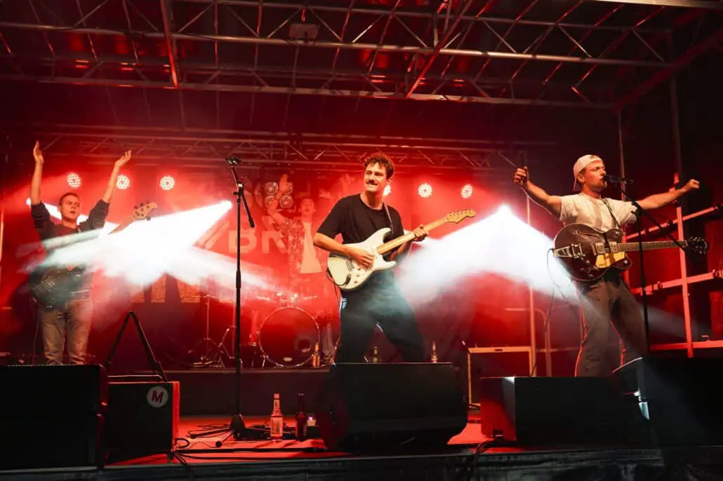 Band spielt live auf einem Festival mit Lichteffekten.