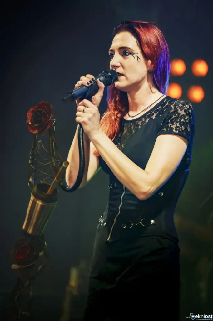 Sängerin mit roten Haaren singt ins Mikrofon.
