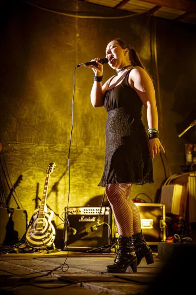 Sängerin performt leidenschaftlich auf Bühne.