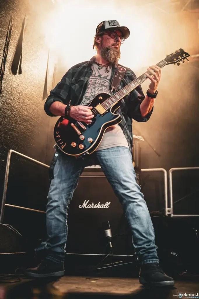 Gitarrist spielt live auf Bühne neben Marshall-Verstärker.