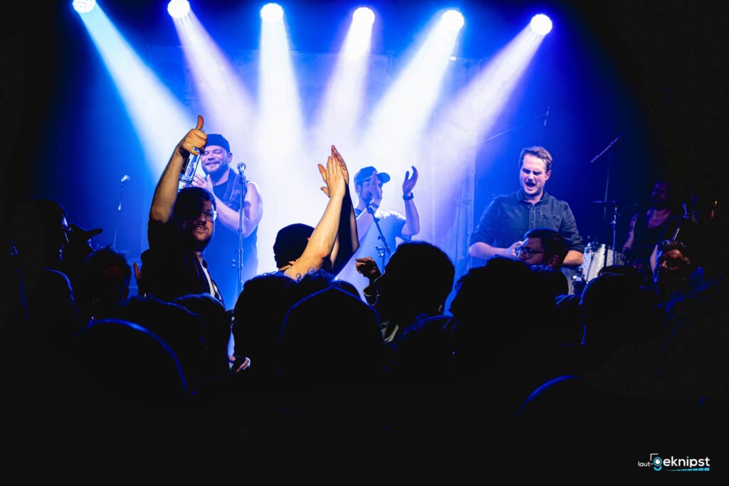 Konzert mit jubelndem Publikum vor der Bühne.