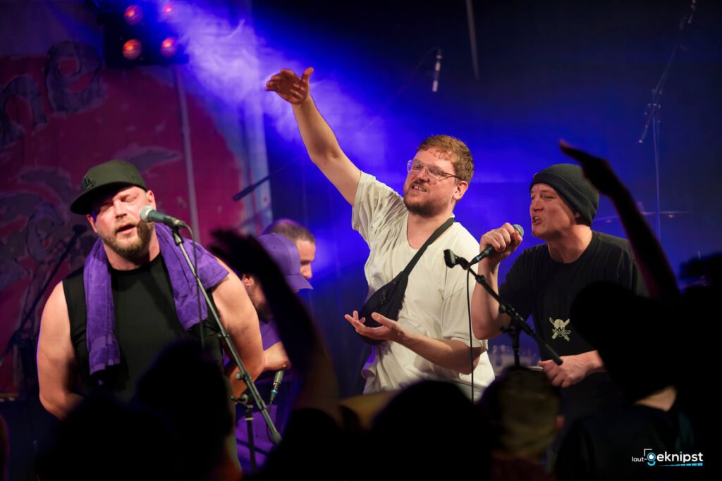 Band singt auf einer Bühne beim Konzert