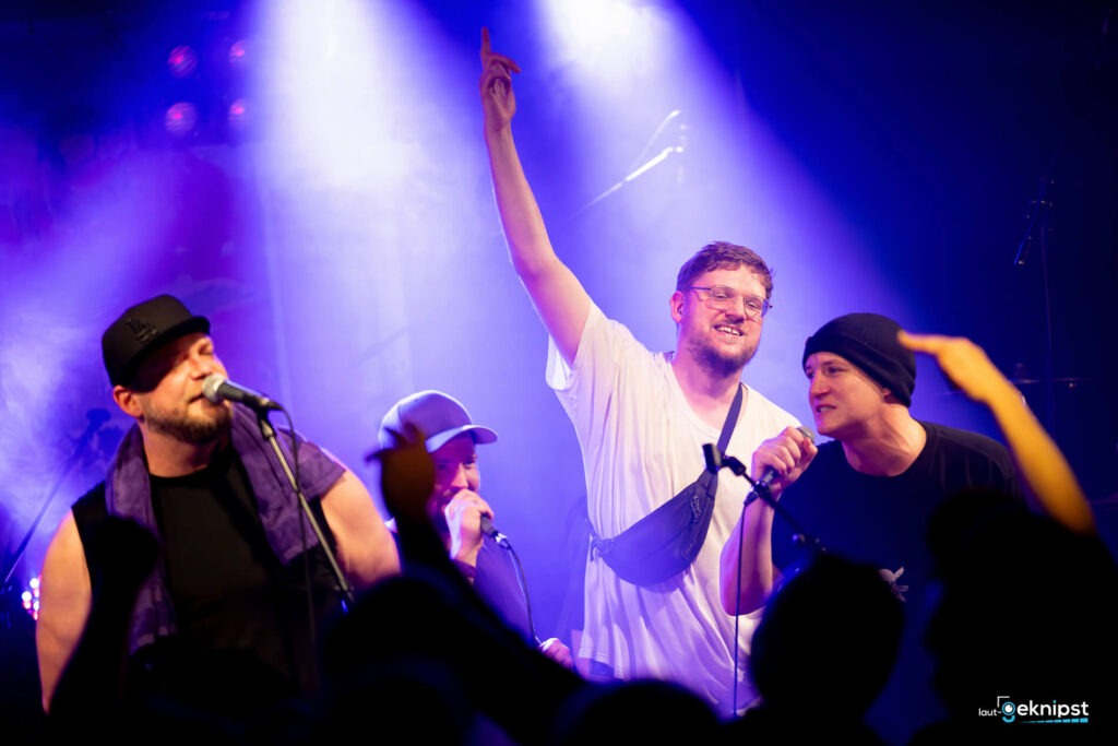 Band singt auf der Bühne vor Publikum