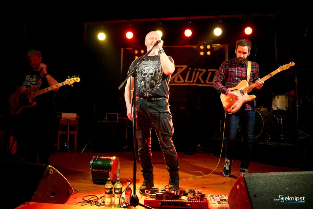 Live-Musikband auf Bühne mit Gitarren und Mikrofon.