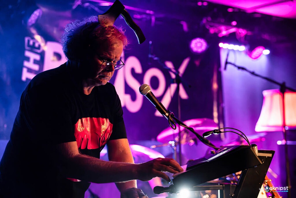 Mann spielt Keyboard bei Konzert, bunt beleuchtet.