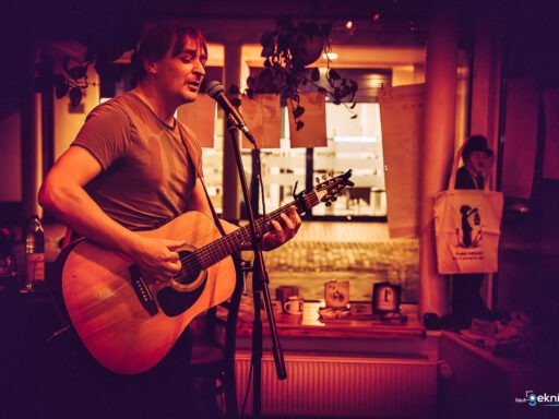 Musiker spielt Gitarre und singt im Café.