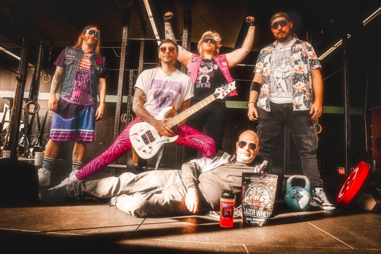 Rockband posiert mit Musikinstrumenten im Fitnessstudio