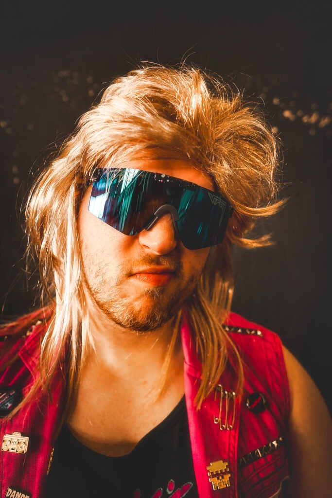 Person mit Sonnenbrille und Mullet-Frisur