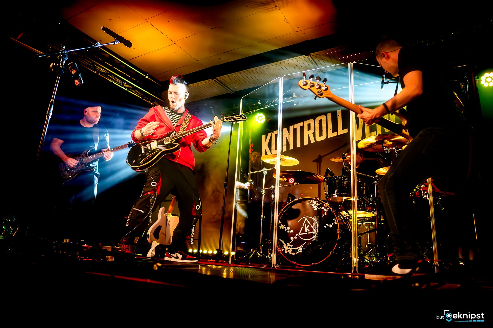 Band spielt live auf Bühne mit Lichteffekten.