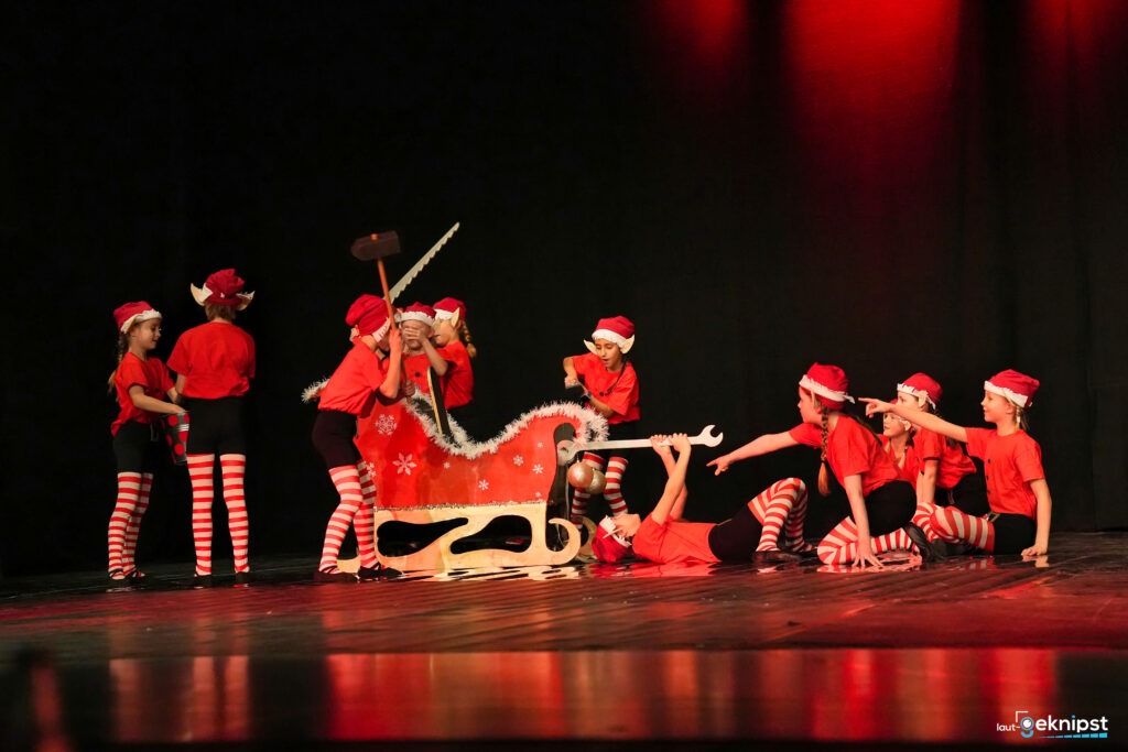 Kinder stellen Weihnachtstheater mit Schlitten dar.