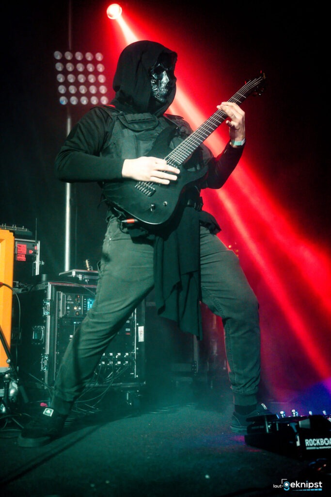 Gitarrist in Maske bei Rockkonzert auf der Bühne