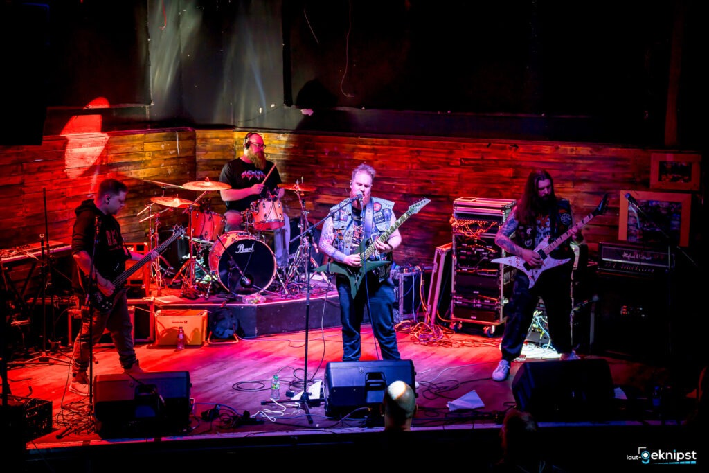 Band spielt Rockmusik auf Bühne.