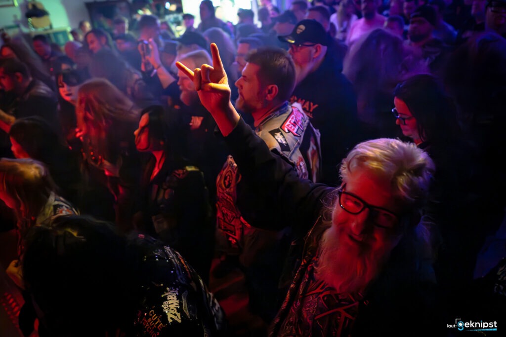 Rockkonzert-Publikum feiert mit Handzeichen.