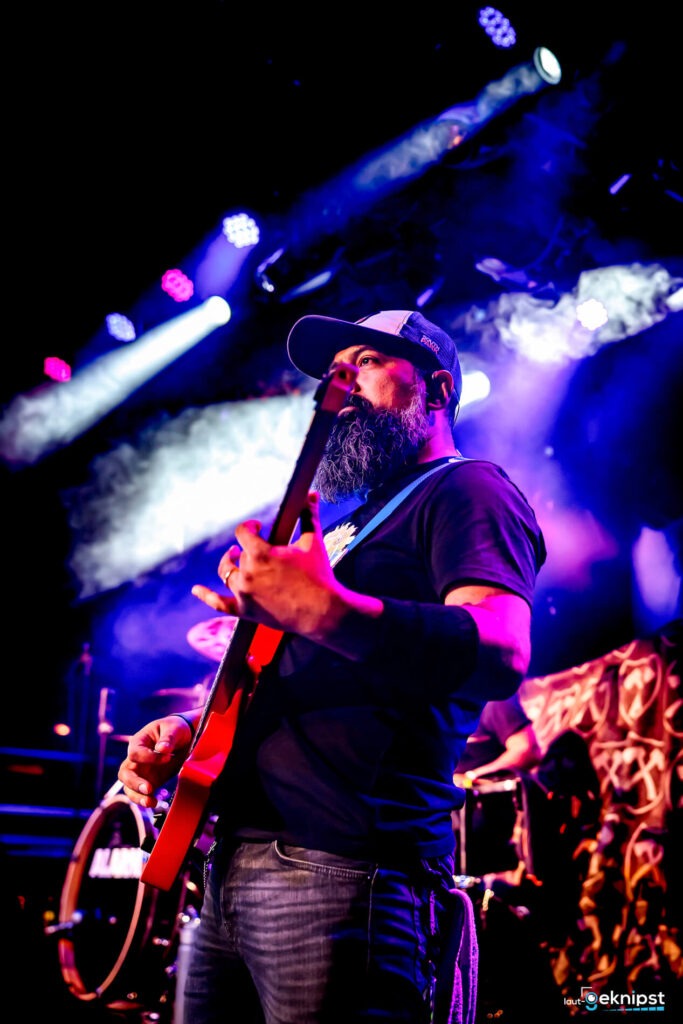 Gitarrist auf der Bühne mit roter Gitarre