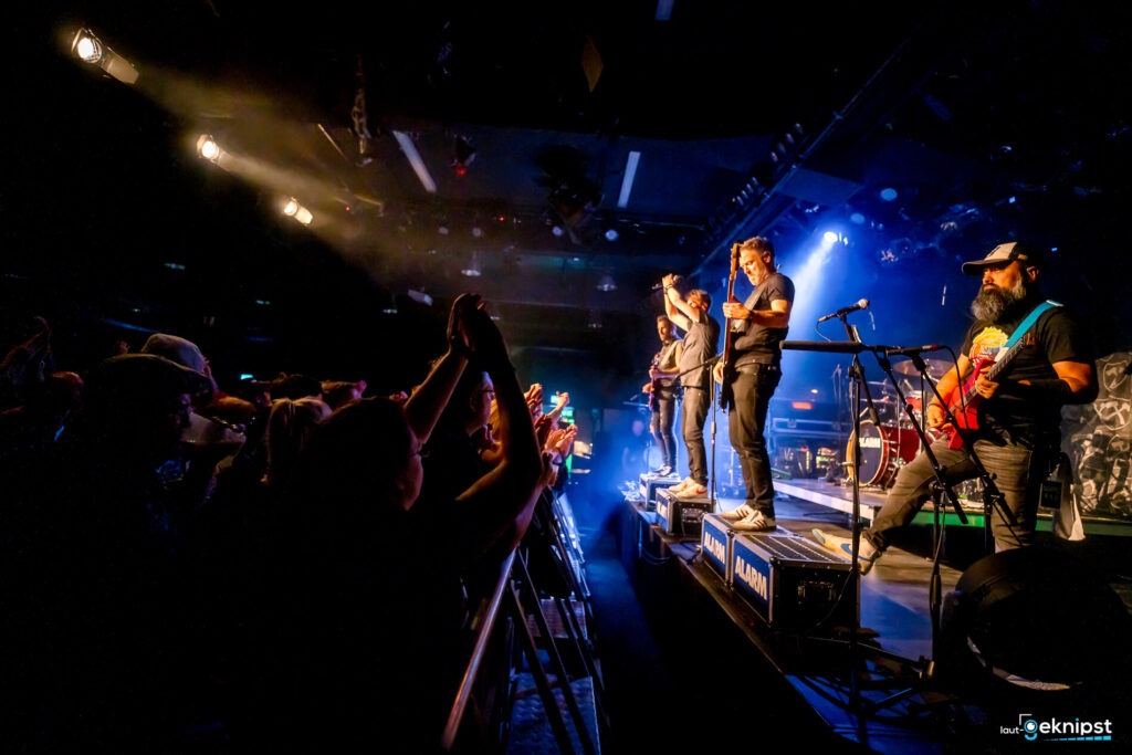 Band spielt vor jubelndem Publikum auf der Bühne.