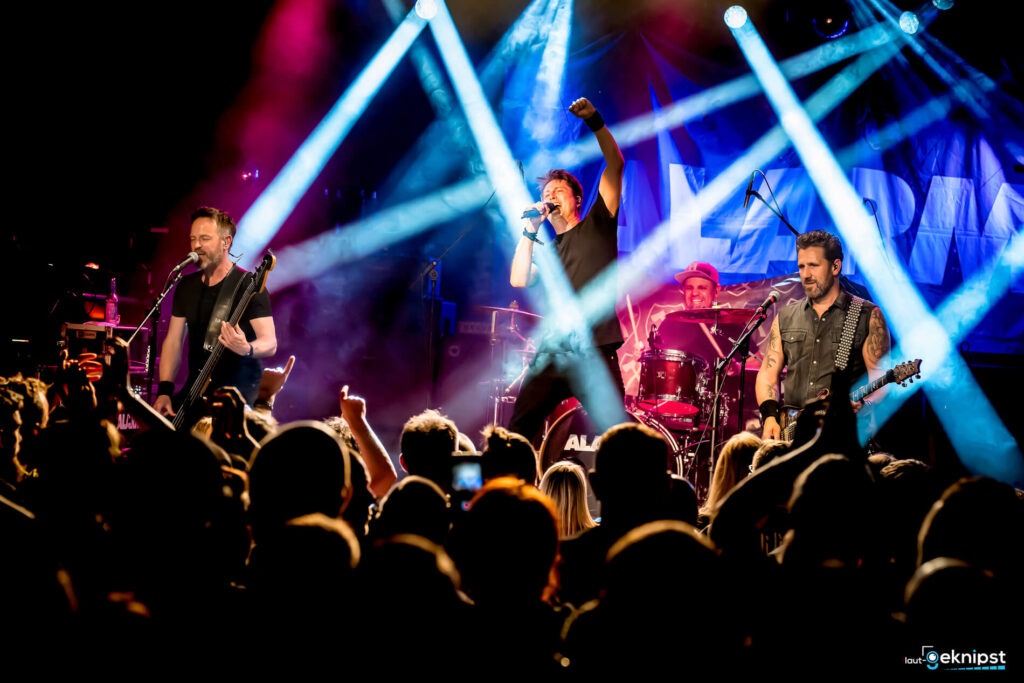 Live-Bandauftritt mit Scheinwerferlichtern auf Bühne.