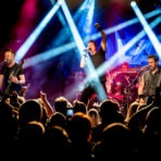 Live-Bandauftritt mit Scheinwerferlichtern auf Bühne.