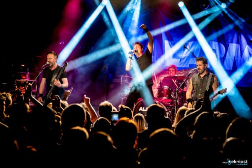 Live-Bandauftritt mit Scheinwerferlichtern auf Bühne.
